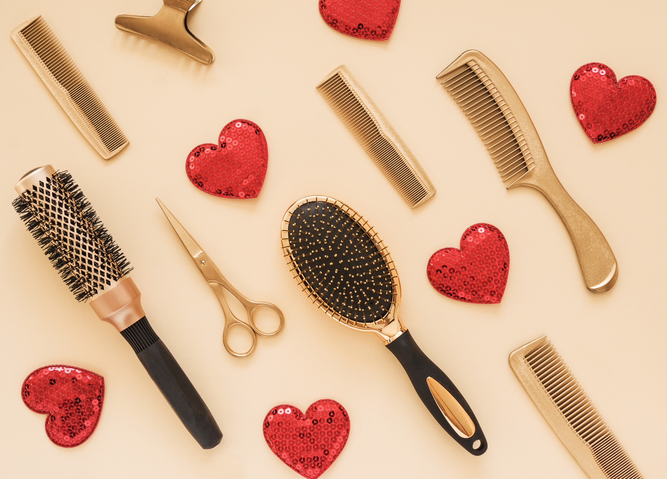 Valentines day background with hairdressing tools and hearts. Gold hair salon accessories.